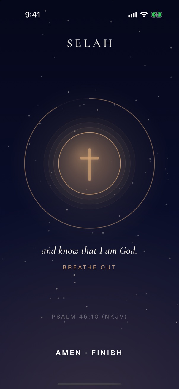 The still moment at night: a gold cross inside rings, the words and know that I am God, Breathe out, Psalm 46:10.